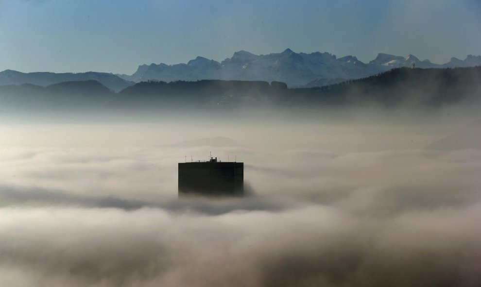 El punto más alto de la Torre Prime (126 metros-413 pies) asoma entre la niebla a primeras horas de la mañana en Zúrich, Suiza. La torre está situada en frente de los Alpes suizos. REUTERS / Arnd Wiegmann