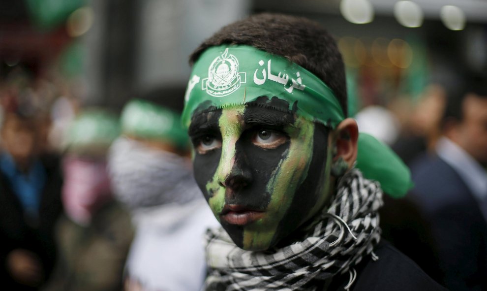 Niño palestino con el rostro pintado participa en una manifestación por el 28 aniversario de la fundación de Hamas, en la ciudad de Gaza.  REUTERS/Suhaib Salem