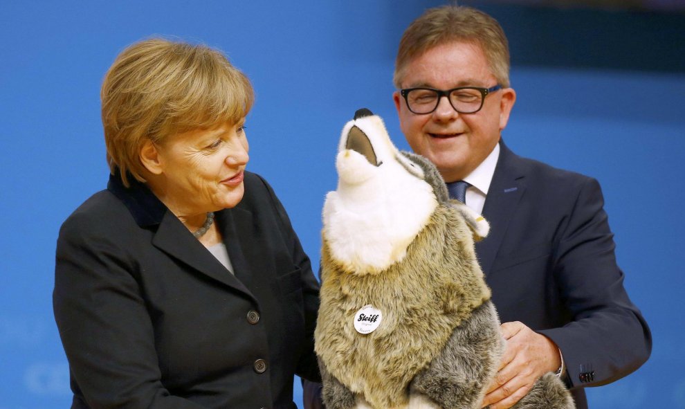 La canciller alemana Angela Merkel recibe un perro de juguete como regalo durante un congreso del partido CDU en Karlsruhe, Alemania.  REUTERS/Kai Pfaffenbach