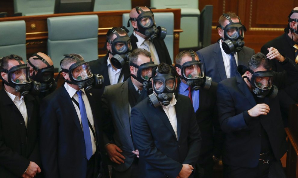 Diputados utilizan máscaras antigás después de que miembros de la oposición lanzaran gas lacrimógeno durante una sesión parlamentaria en Pristina, Kosovo. EFE/Valdrin Xhemaj