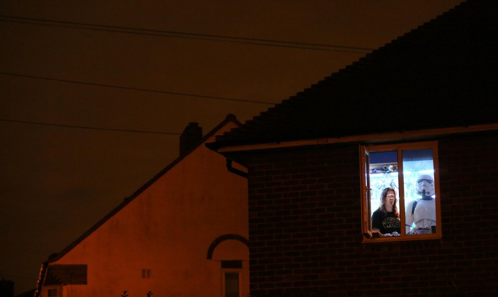 La diseñadora gráfica y coleccionista de Star Wars posa disfrazada de Stormtrooper con su compañera sentimental en la ventana de su casa al sur de Londres. REUTERS/Paul Hackett