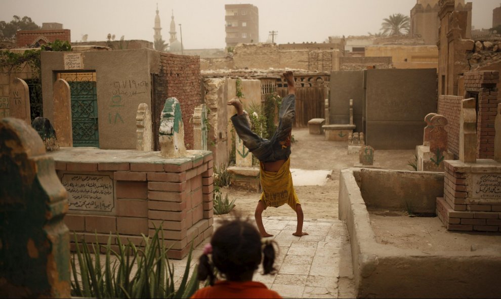 Un niño juega entre las tumbas de la Ciudad de los Muertos, la necrópolis de El Cairo donde habitan desce hace cientos de años docenas de miles de personas. REUTERS/Asmaa Waguih