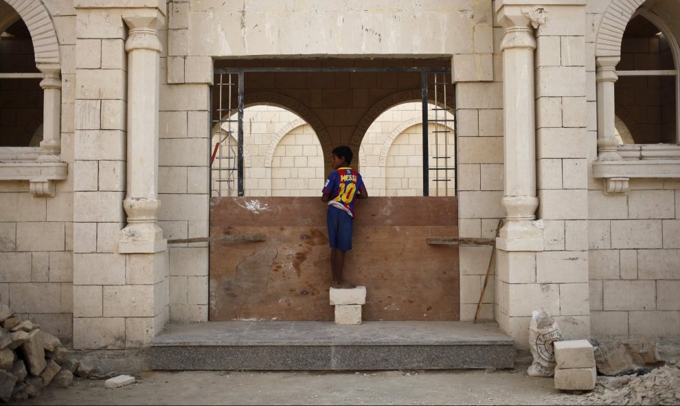 Un niño observa un nuevo panteón en uno de los callejones de la Ciudad de los Muertos, la necrópolis de El Cairo en la que habitan miles de personas. REUTERS/Asmaa Waguih