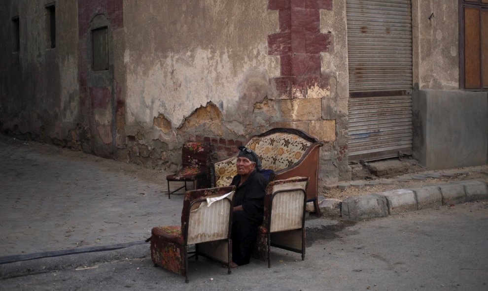 Una mujer sentada en unas sillas en uno de los callejones de la Ciudad de los Muertos, la necrópolis de El Cairo en la que residen miles de personas. REUTERS/Asmaa Waguih