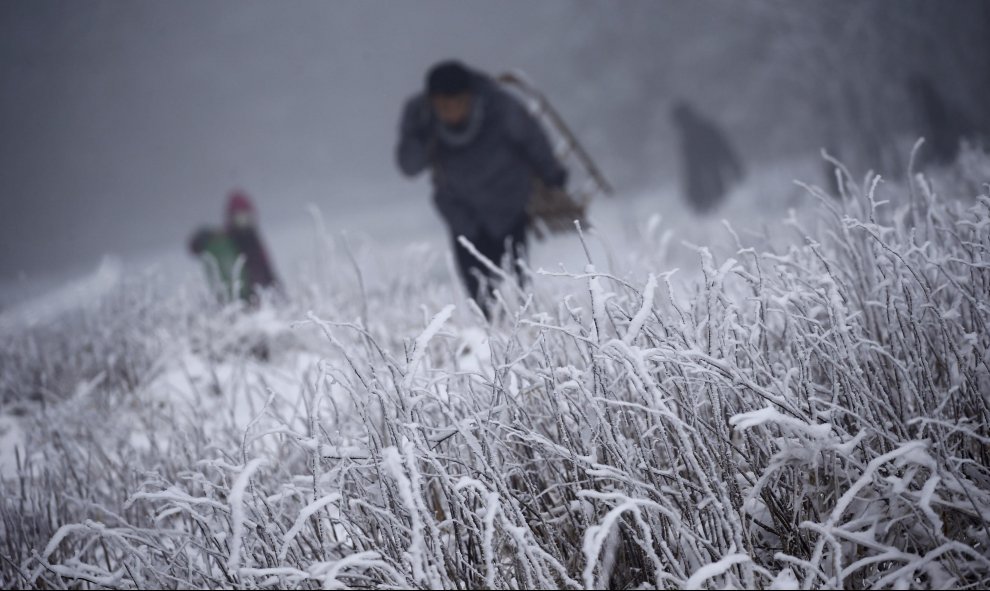 Personas suben una colina durante la primera nevada de este invierno en la montaña de Feldberg, cerca de Frankfurt, en Alemania. REUTERS/Kai Pfaffenbach