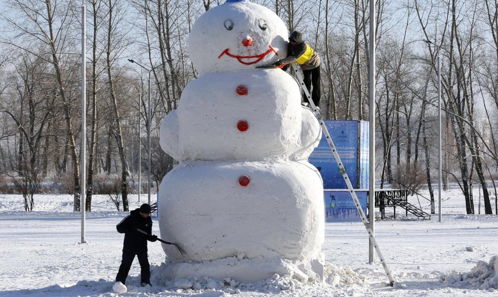 Hombres trabajan en un muñeco de nieve de 5 metros de altura en un parque en una ciudad siberiana de Krasnoyarsk. REUTERS/Ilya Naymushin