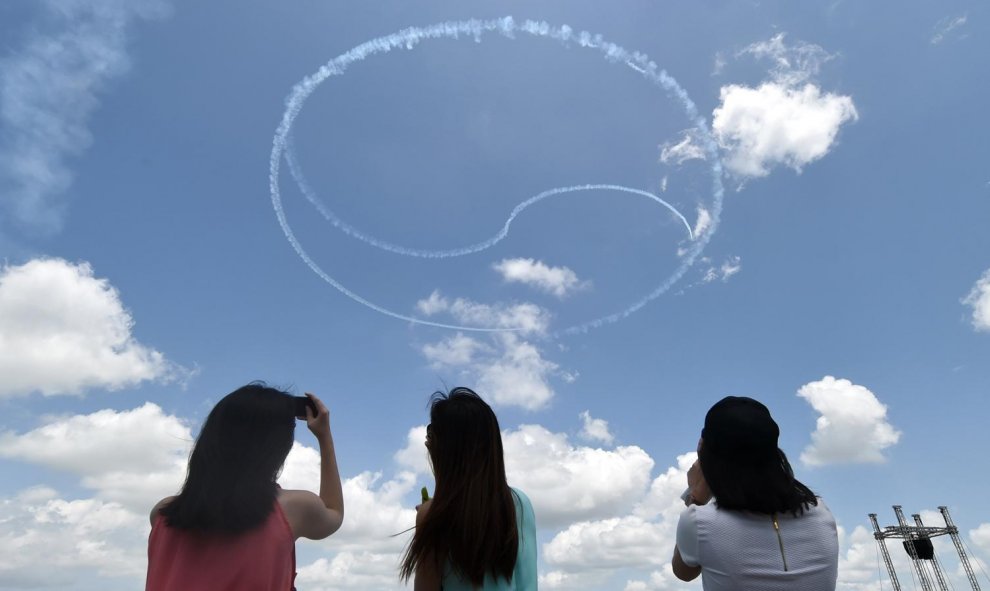 El equipo de acrobacia de las Águilas Negras de Corea del Sur realiza una exhibición aérea formando el logotipo del Ying y Yang durante el Salón Aeronáutico de Singapur en el centro de exposiciones de Changi en Singapur el 16 de febrero de 2016. AFP PHOTO