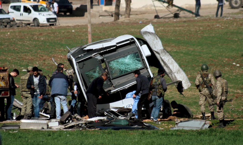 Los soldados y los oficiales de seguridad analizan un vehículo militar dañado cerca de Diyarbakir, Turquía después de que una bomba explotara por control remoto y matara a siete miembros de las fuerzas de seguridad turcas que viajaban en un vehículo milit