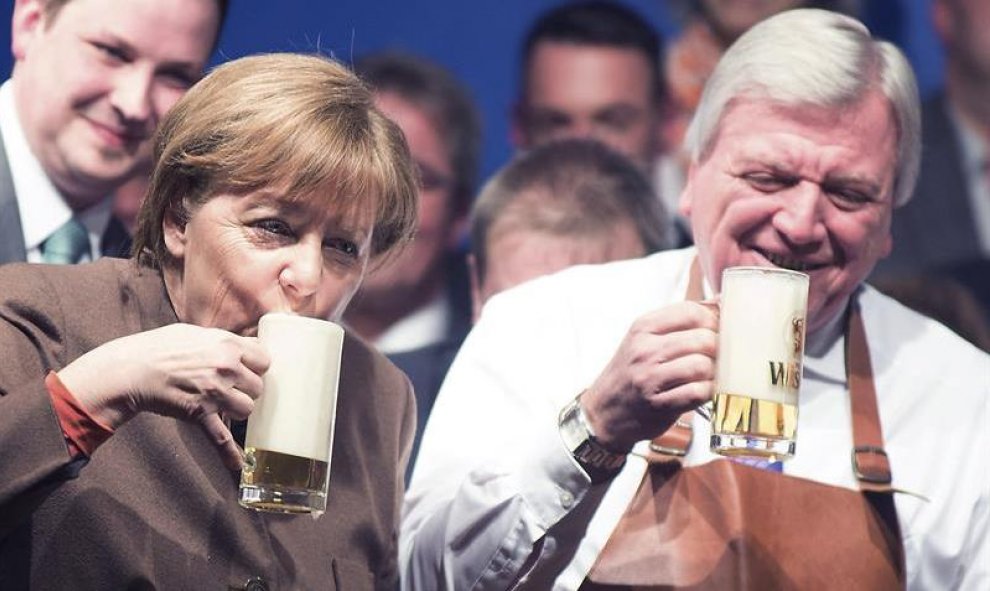 La canciller alemana, Angela Merkel y el primer ministro de Hesse, Volker Bouffier, beben una cerveza durante el tradicional encuentro que celebra cada Miércoles de Ceniza la Unión Cristianodemócrata (CDU), en Volkmarsen, Alemania. EFE/Swen Pfoertner