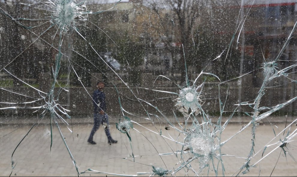 Un hombre pasa por delante de un escaparate roto por los enfrentamientos entre las fuerzas especiales y los militantes del PKK en Cizre, provincia de Sirnak. EFE/Cem Turkel