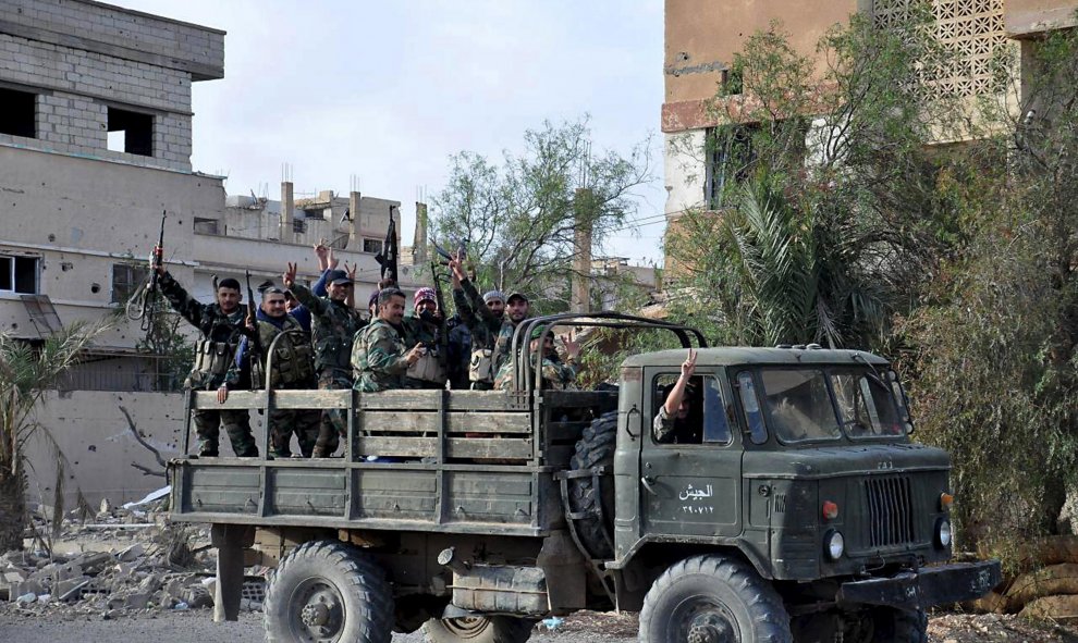 Un camion con tropas leales al presidente sirio Bashar al-Assad, hacen el signo de la victoria al pasar por las calles de Palmira tras expulsar al Estado Islámico. REUTERS/SANA