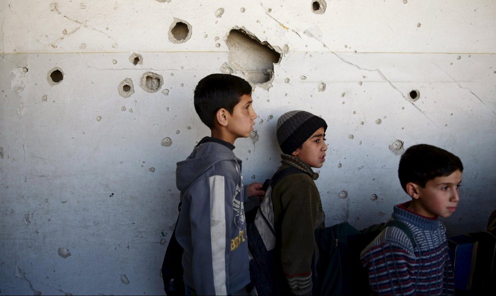 Estudiantes permanecen en su escuela dañada en una zona controlada por los rebeldes en Damasco. REUTERS/Bassam Khabieh