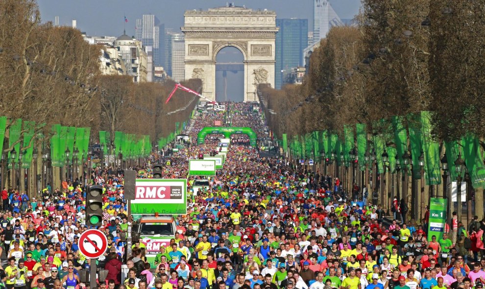 Los participantes corren bajo el arco del triunfo de los Campos Elíseos al inicio de la maratón. REUTERS/Benoit Tessier