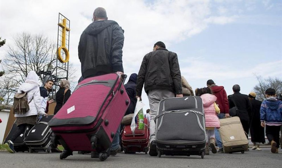 Varios refugiados sirios llegan al centro de primera acogida de la localidad de Friedland, Alemania. EFE/Swen Pfoertner