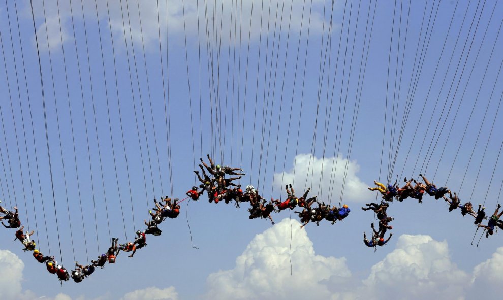 Personas saltan desde un puente en Brasil. REUTERS/Paulo Whitaker