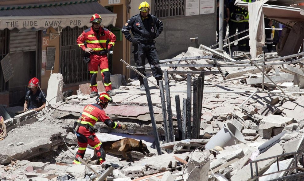 Personal sanitario y militares acompañados con perros especializados trabajan en la retirada de escombros en busca de los desaparecidose en el edificio de Los Cristianos (sur de Tenerife) que se ha derrumbado parcialmente este jueves. EFE/Ramón de la Roch