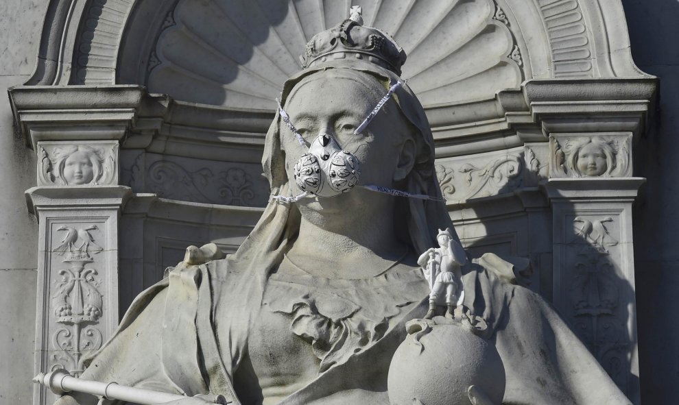 Una representación de una máscara de gas colocada por el grupo ecologista Greenpeace en una estatua de la reina Victoria de Inglaterra, cerca de Buckingham Palace en Londres. REUTERS/Toby Melville