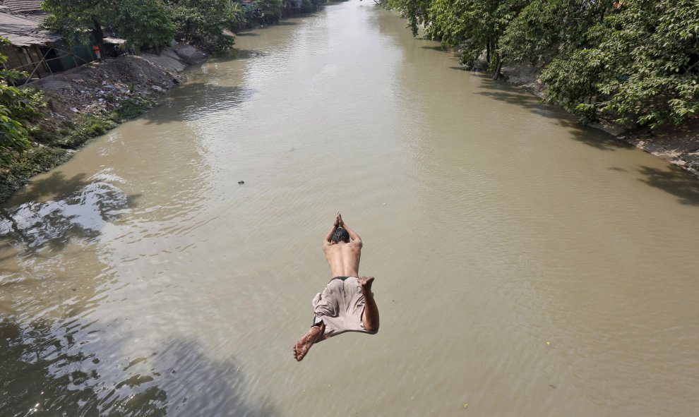 Un hombre salta a un rio para refrescarse en un día caluroso en Calcuta. REUTERS/Rupak De Chowdhuri