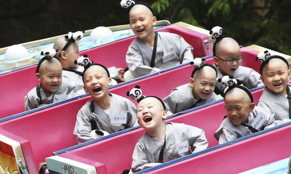Jóvenes monjes budistas disfrutan de una atracción en un parque de atracciones en Seúl, Corea del Sur. EFE/Yonhap