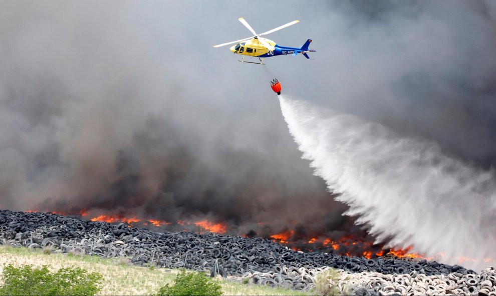 Un helicóptero trata de aplacar las llamas del incendio de neumáticos en Seseña.-  REUTERS/Sergio Perez