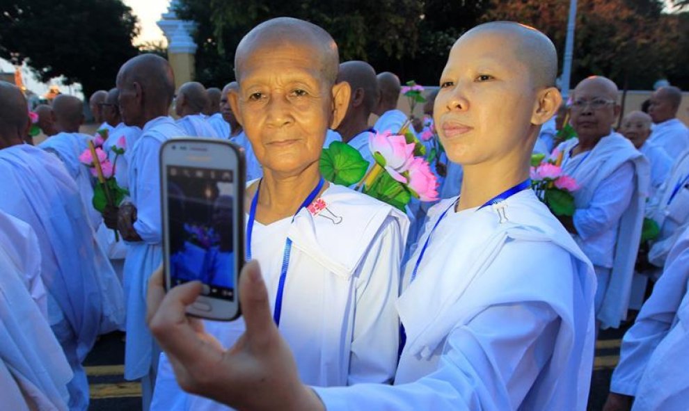 Dos monjas budistas se hacen un selfie durante las celebraciones del Vesak Bochea en Phnom Penh, en Camboya. EFE/Kith Serey