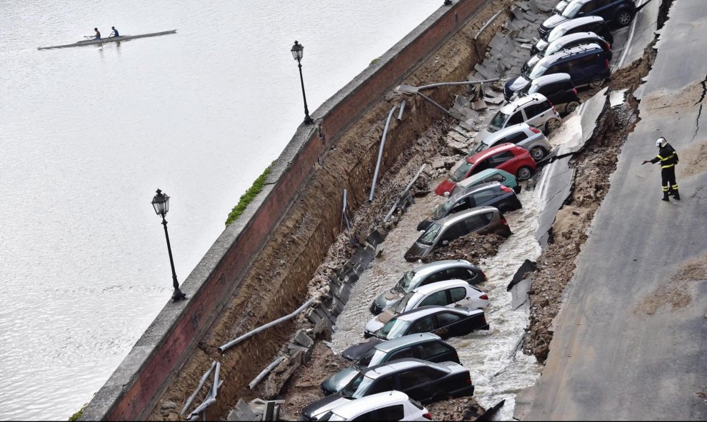 Varios vehículos aparecen engullidos por un socavón cerca del famoso Puente Viejo a orillas del río Arno, en el centro de la ciudad italiana de Florencia (Italia). EFE/Maurizio Degl' Innocenti