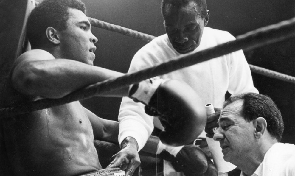 Cassius Clay, en el rincón del ring, con su entrenador Angelo Dundee  y su asistente, en el combate contra el alemán German Karl Mildenberger en Fráncfort, el 10 de septiembre de 1966. EFE/EPA/DPA FILES