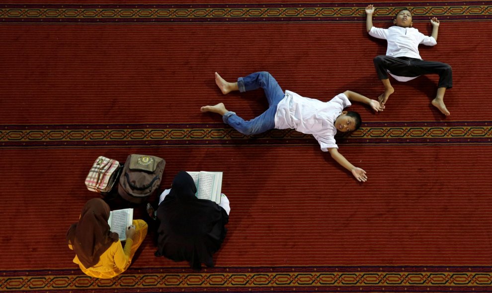 Mujeres leen el Corán mientras los niños descansan dentro de la mezquita Istiqlal durante el Ramadán en Jakarta, Indonesia. REUTERS/Beawiharta