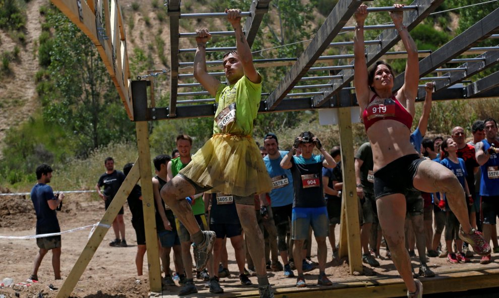 Dos de los participantes durante la 'Mud Day Race', la carrera de obstáculos que ha tenido lugar en la base militar de El Goloso, a las afueras de Madrid. REUTERS/Juan Medina