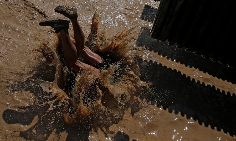 Uno de los participantes de la 'Mud Day Race' cae al barro. REUTERS/Juan Medina