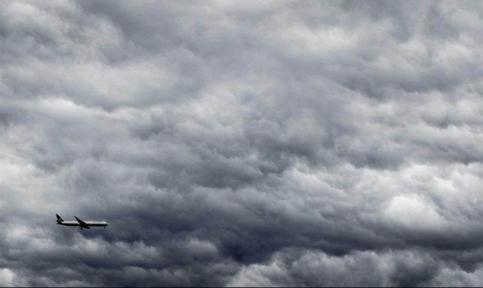 Un avión vuela bajo las nubes grises que se ciernen sobre la ciudad holandesa de Haarlem. EFE/Koen Van Weel