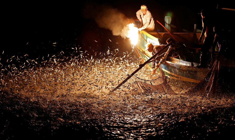 Pescadores utilizan fuego para atraer a los peces en un barco tradicional de pesca en Taiwán. REUTERS / Tyrone