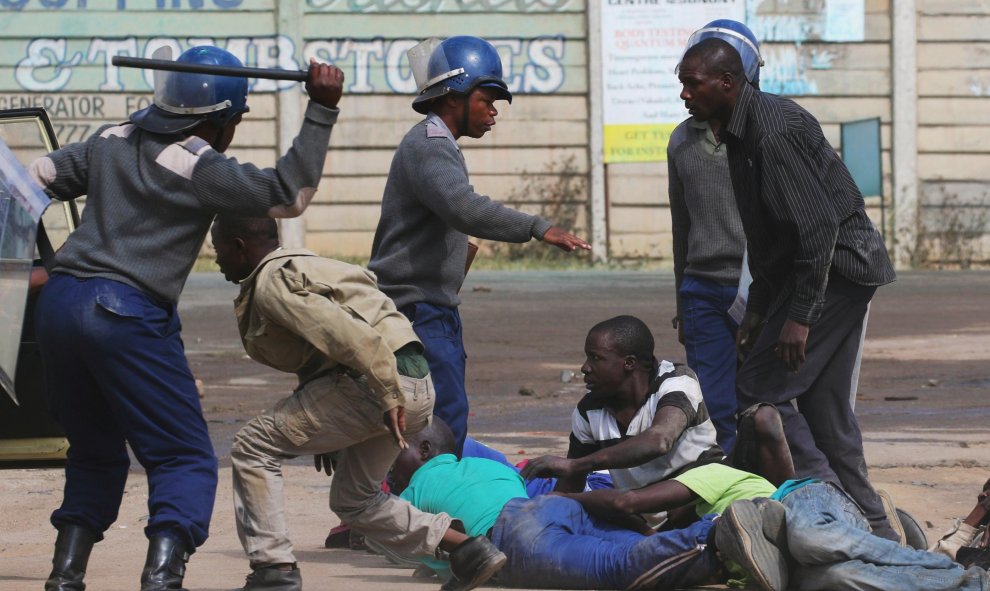 Policías antidisturbios cargan contra los residentes del barrio de Epworth después de que una protesta de taxistas se tornó violenta en Harare, Zimbabwe.-REUTERS / Philimon Bulawayo TPX IMÁGENES DEL DÍA