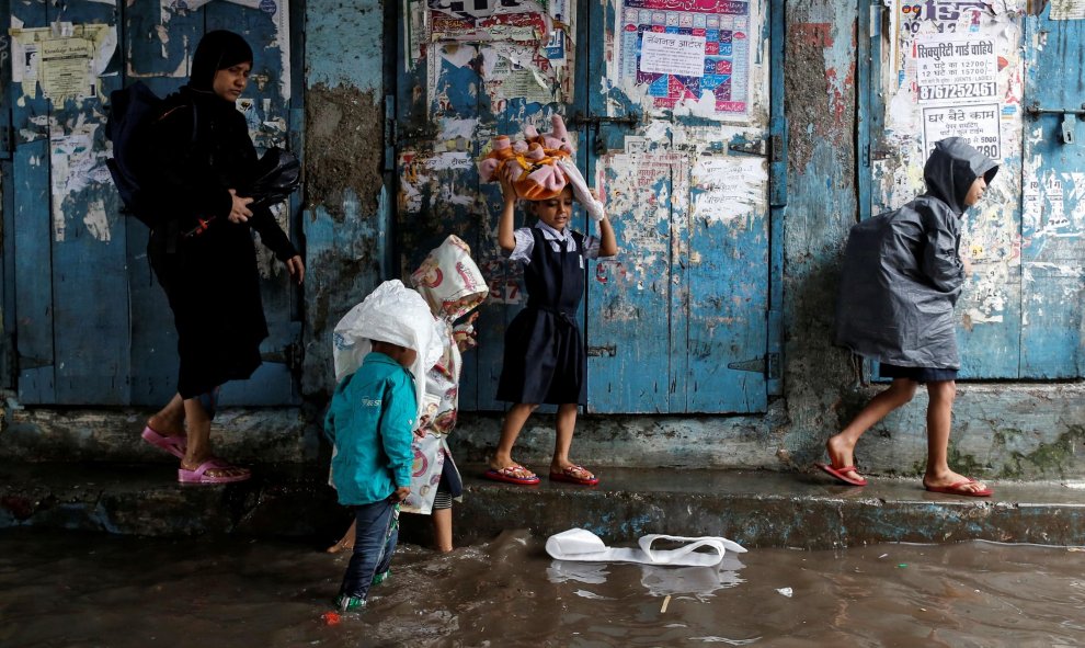 Unos niños se dirigen a la escuela tras las grandes inundaciones que ha sufrido Mumbai, en la India/REUTERS