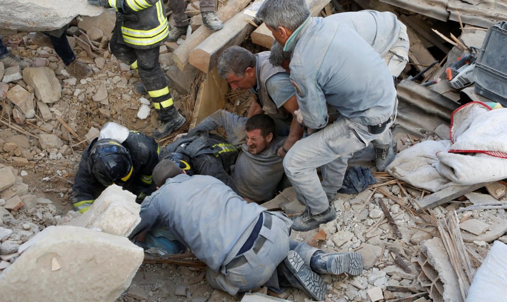 Un hombre es rescatado con vida de entre los escombros que ha dejado el terremoto en Amatrice/REUTERS