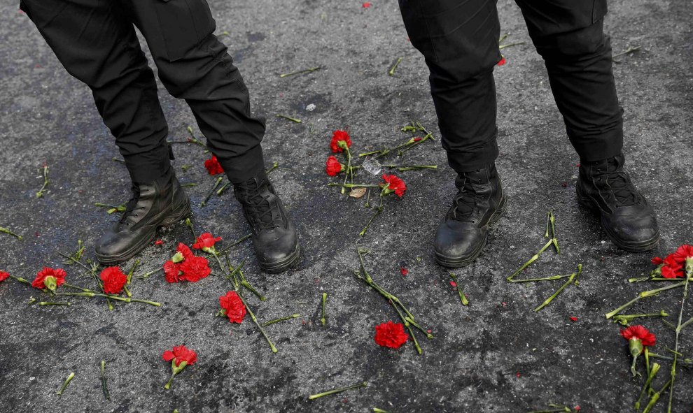 La gente coloca flores frente a los policías turcos que permanecen de guardia cerca de la discoteca Reina de Estambul donde se produjo el atentado. REUTERS / Umit Bektas