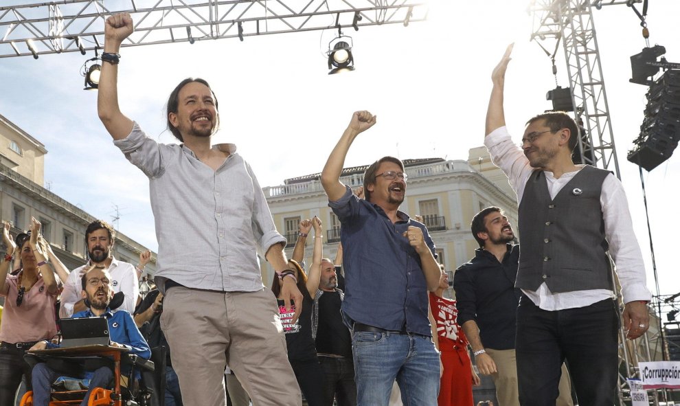 El líder de Podemos Pablo Iglesias (c), junto al secretario de Organización, Pablo Echenique (i), el líder de En Comú, Xavier Domenech (2ºd), y Juan Carlos Monedero (d), participan en la Puerta del Sol de Madrid en la concentración convocada en favor de l