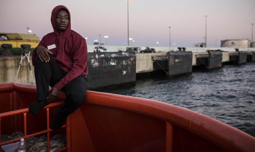 Abdoul Kalash, de 15 años y originario de Guinea Konacry, observa Algeciras desde el puerto, donde lleva durmiendo tres días seguidos tras ser rescatado en el Estrecho de Gibraltar cuando viajaba en una patera. JAIRO VARGAS