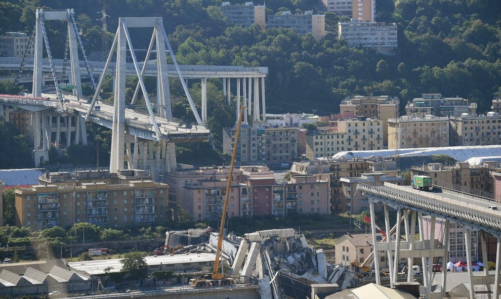 Vista del puente Morandi, en la Autopista A10 italiana, a su paso por Génova,mientras una grúa trabaja en las labores de búsqueda de víctimas y retirada de los escombros tras el derrumbe de una sección este martes. EFE/ Luca Zennaro