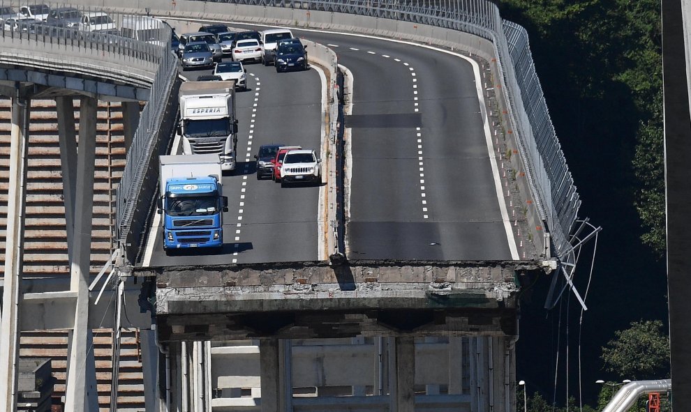 Varios vehículos permanecen sobre una sección de un puente que continúa en pie tras el desplome de un tramo el martes en Génova (Italia). EFE/ Luca Zennaro
