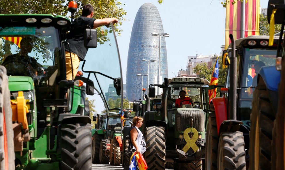 Una mujer camina entre tractores el día de la Diada en Barcelona, que está marcado por un clima político cargado. /  REUTERS - ENRIQUE CALVO
