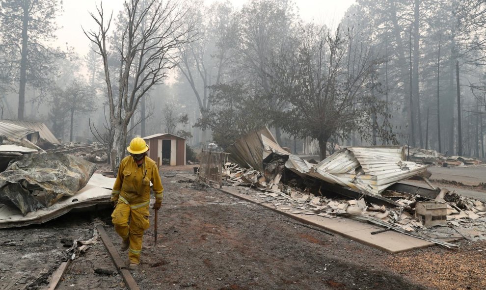 Un bombero de Cal Fire camina entre las casas destruidas por el devastador incendio en Camp Fire, Paradise.- REUTERS