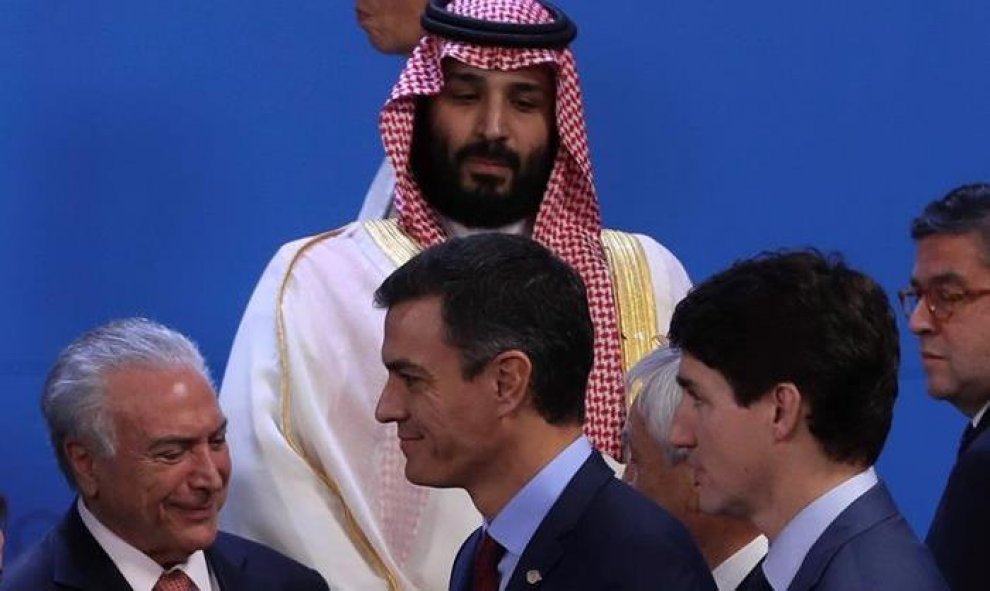 El presidente del Gobierno español, Pedro Sánchez (centro) y el primer ministro de Canadá, Justin Trudeau (dcha), caminan frente al príncipe heredero saudí, Bin Salman (centro-detrás), y el presidente de Brasil, Michel Temer (izq). / EFE - BALLESTEROS