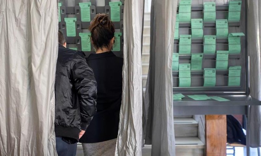 02/12/2018.- Una pareja escoge la papeleta para elegir a su candidato hoy en el colegio electoral ubicado en la biblioteca de San Lúcar de Barrameda(Cádiz). EFE/Jose Manuel Vidal.