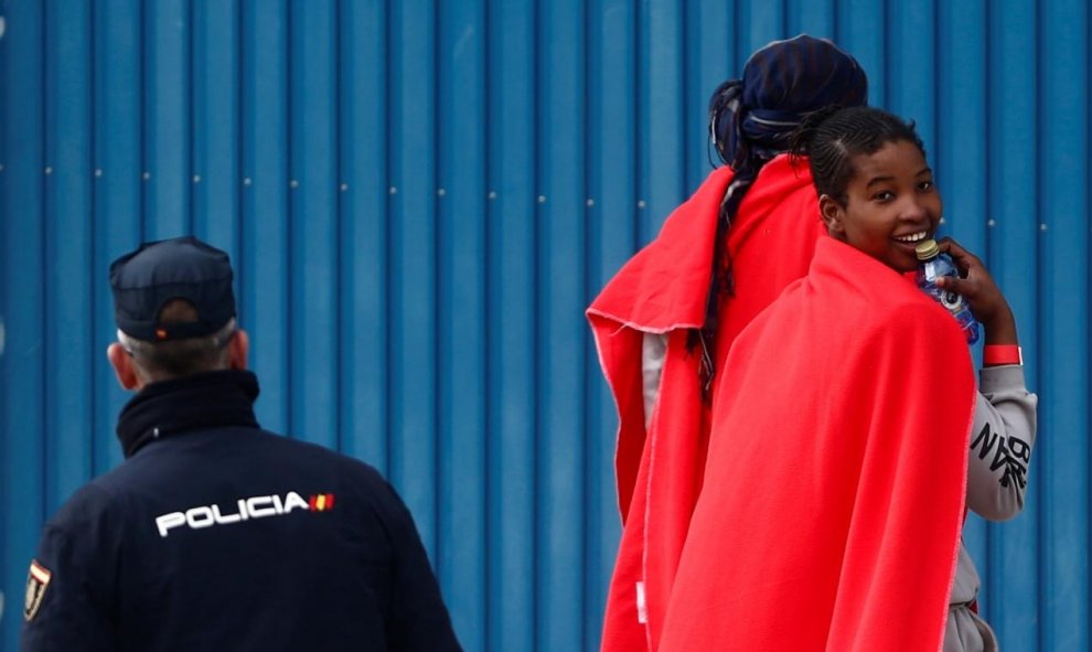 Una joven migrante rescatada en el Mediterráneo muestra su alegría tras desembarcar del Open Arms