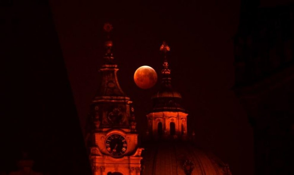 La luna de sangre vista entre la iglesia de San Nicolás, en Praga, República Checa. Michal CIZEK / AFP