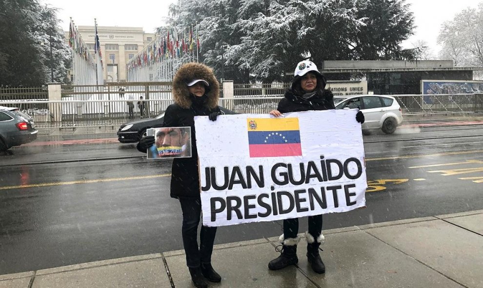 Dos venezolanas sujetan una pancarta en apoyo al líder opositor de Venezuela Juan Guaidó ante la sede europea de Naciones Unidas en Ginebra. / EFE - ANTONIO BROTO