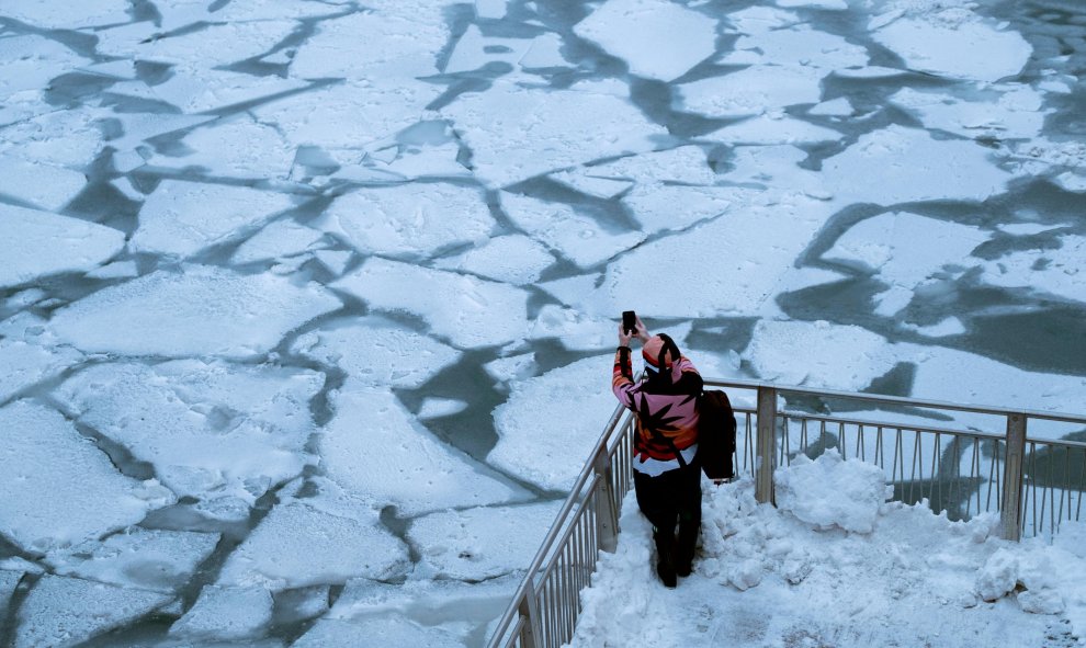 Una mujer fotografía el río de Chicago congelado por las bajas temperaturas que afectan al medio oeste de Estados Unidos. / REUTERS-Pinar Istek