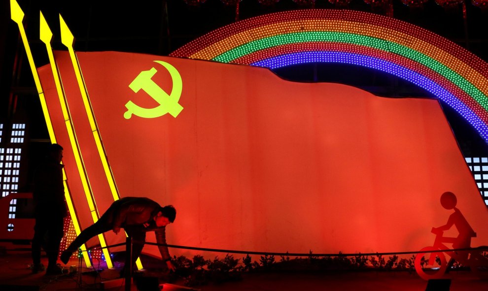 Unos hombres verifican una instalación de luz con la forma de la bandera del partido del Partido Comunista de China, que se creó para celebrar el próximo Año Nuevo Lunar Chino, en Jining, Shandong | Reuters