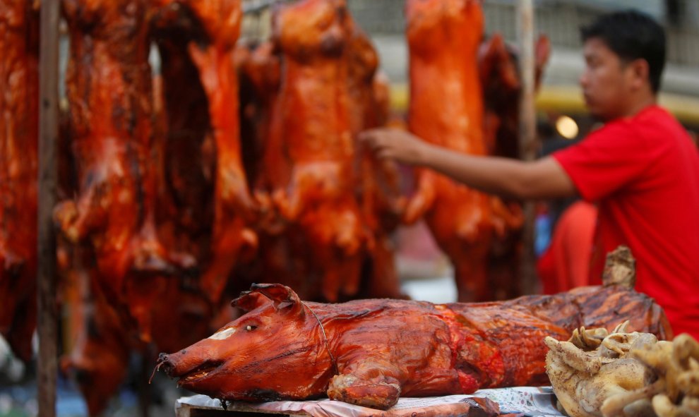 Un hombre compra cerdos asados ​​a lo largo de una calle antes del Año Nuevo Lunar Chino, en Phnom Penh, Camboya | Reuters/Samrang Pring